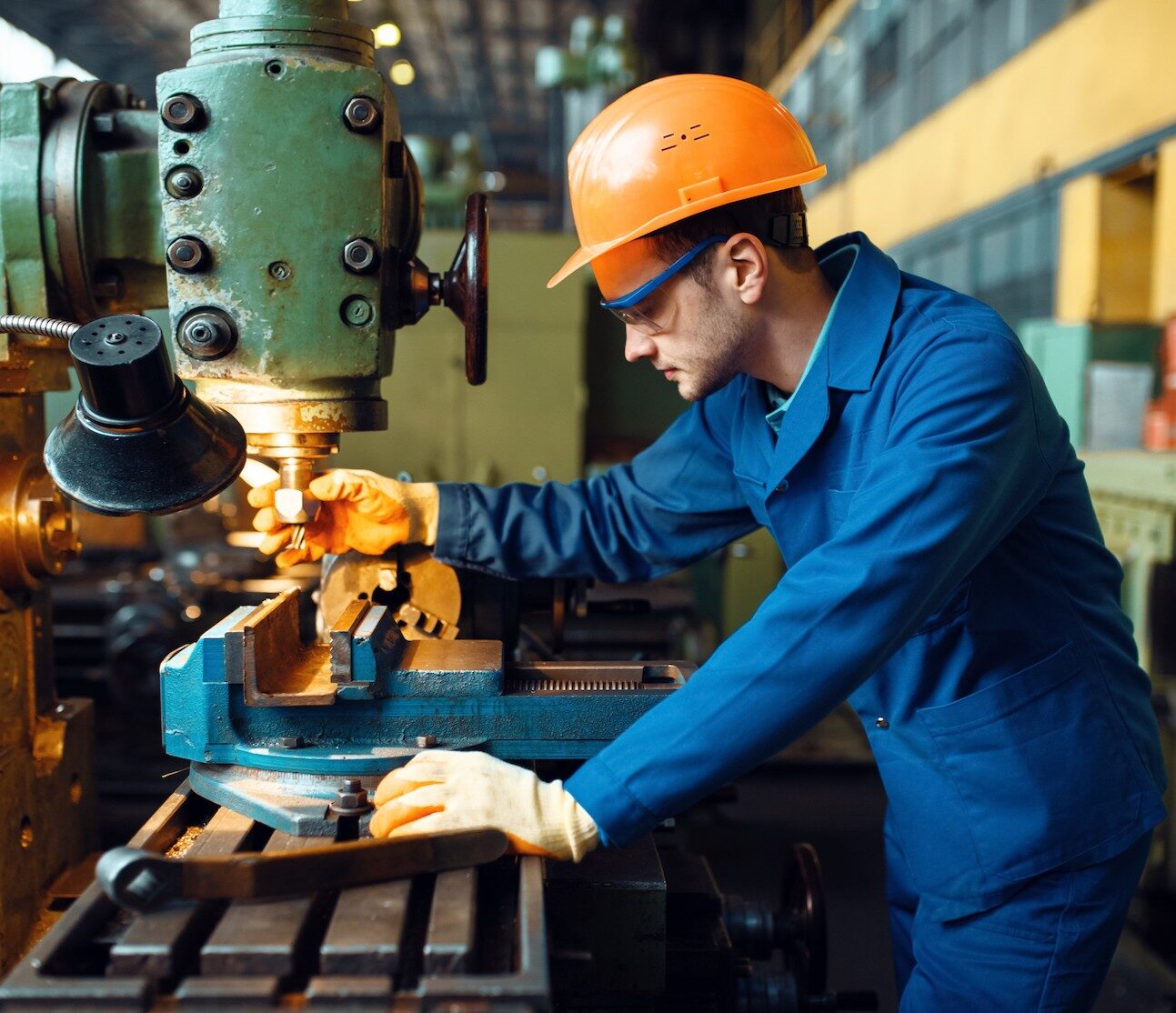 Male technician works on lathe, plant